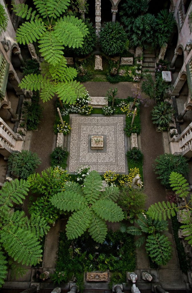 Courtyard garden at Isabella Stewart Gardner Museum with tropical plants and flowers.