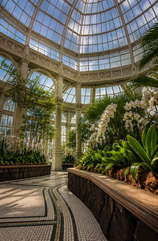 Victorian glass dome of the Enid A. Haupt Conservatory with diverse plant displays.