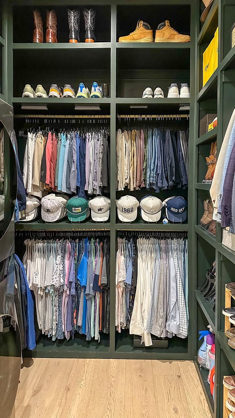 Dark green custom closet system with organized shoes, boots, and hanging clothing sections.