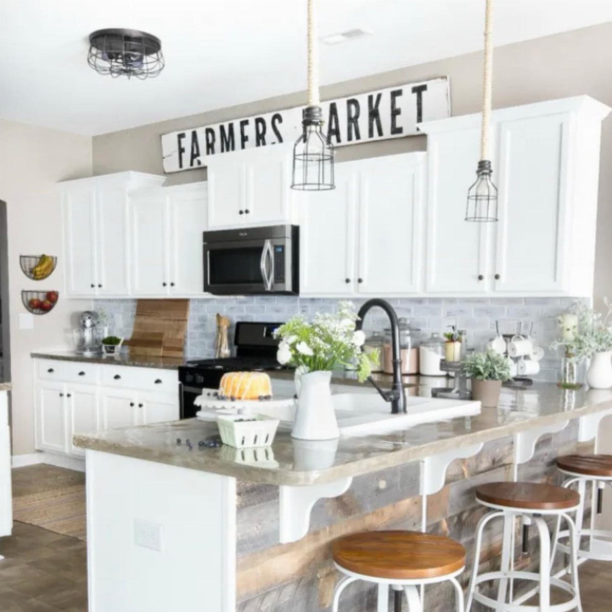 White kitchen cabinets with a large Farmers Market sign decorating the space above them.