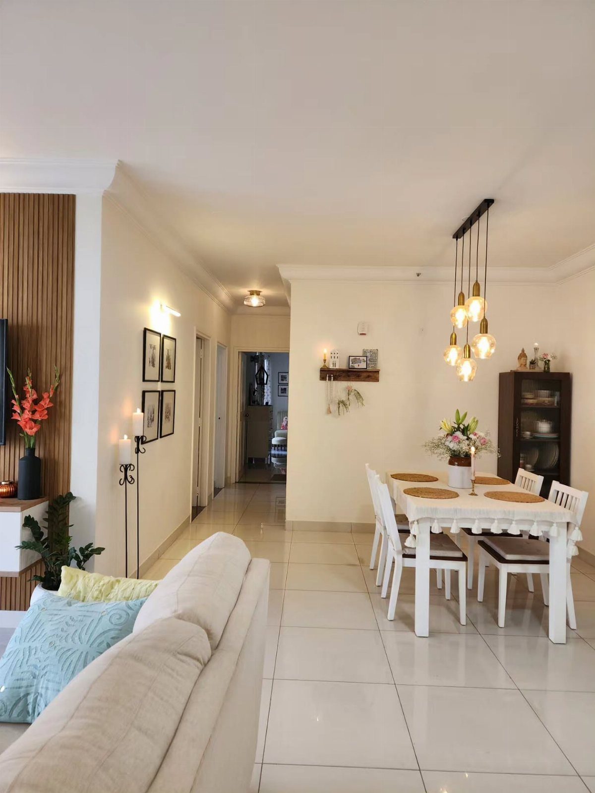 11 Minimalist Dining Room Decor Ideas for Calm, Collected Spaces 6 White dining table with floral centerpiece and pendant lights in a bright, minimalist room.