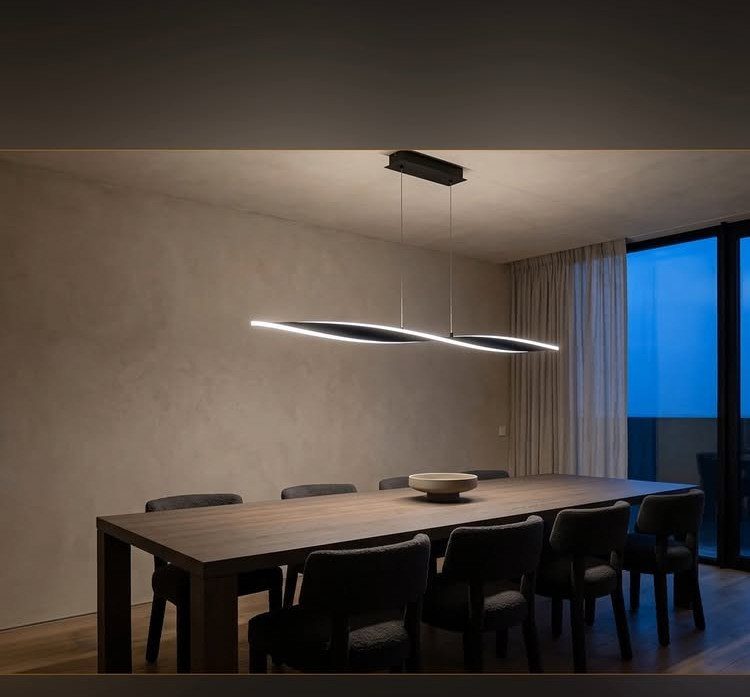 11 Minimalist Dining Room Decor Ideas for Calm, Collected Spaces 3 A long wooden dining table with a single white bowl under a sculptural pendant light.