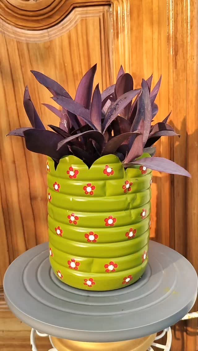 DIY Plants and Decor: 6 Home Projects Worth Making 1 A lime green decorative planter with red flower patterns holding a purple plant.