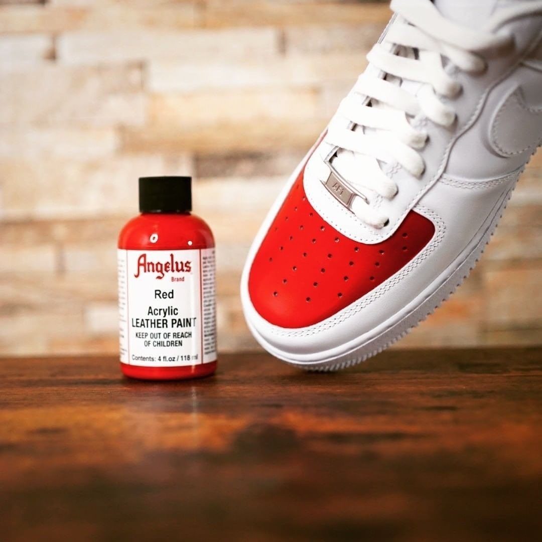 Red painted leather sneaker next to a bottle of red Angelus acrylic leather paint.