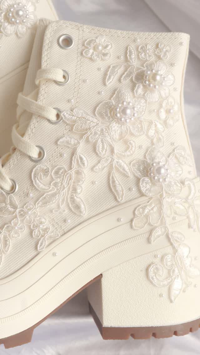 Cream platform lace-up boots decorated with white lace floral appliqués and small pearl beads.
