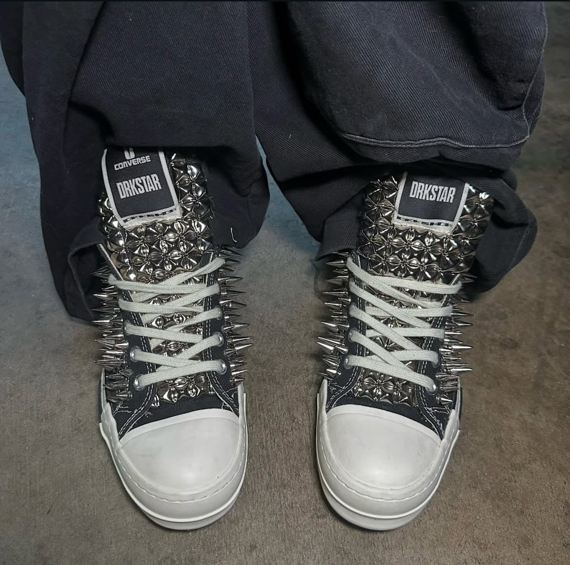 Black high-top sneakers covered in silver metal studs and long sharp spikes.