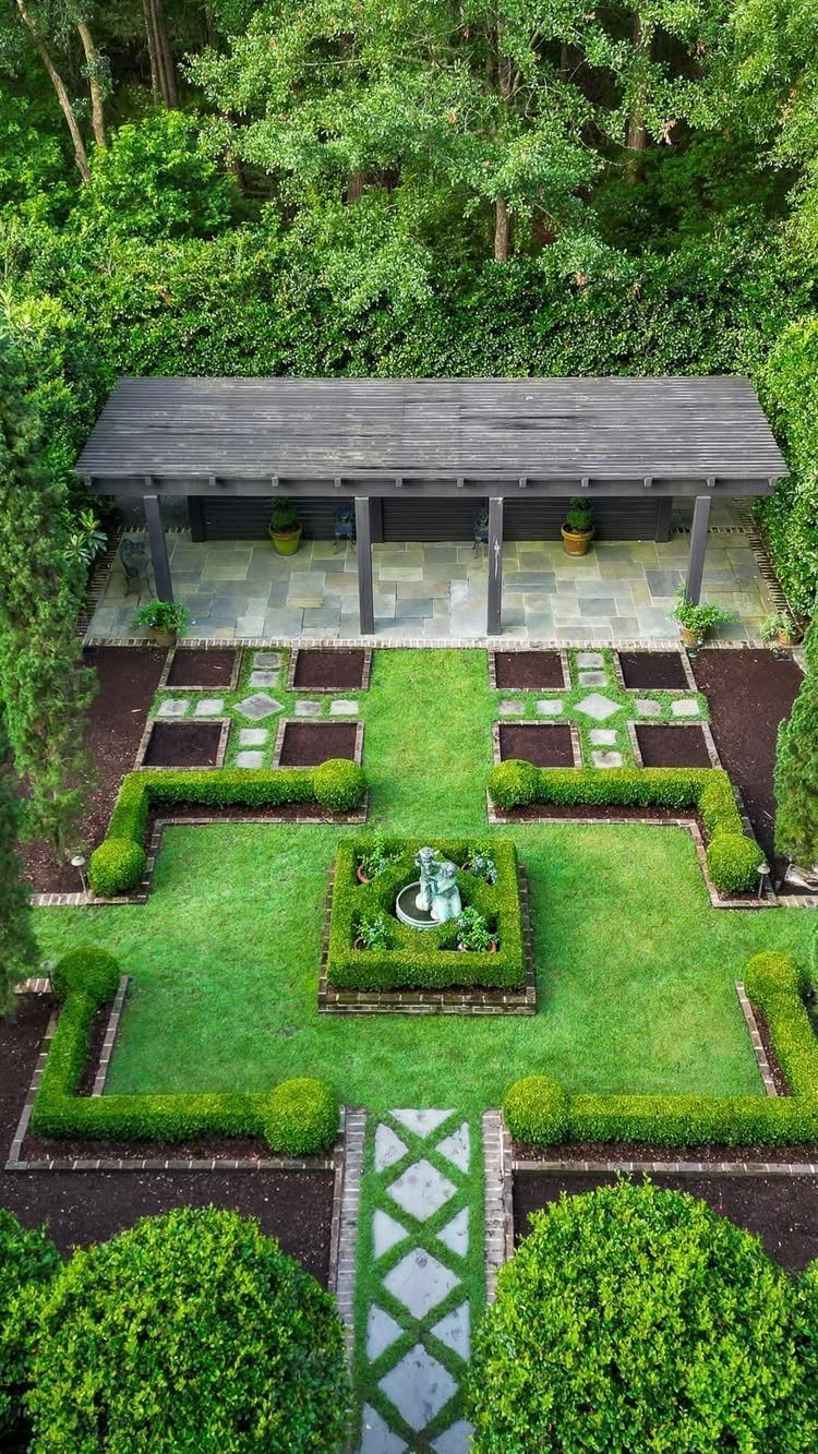 13 Estate Garden Design Ideas With Photos and Planning Tips 8 Symmetrical formal garden with manicured hedges, green lawns, and stone paths viewed from above.