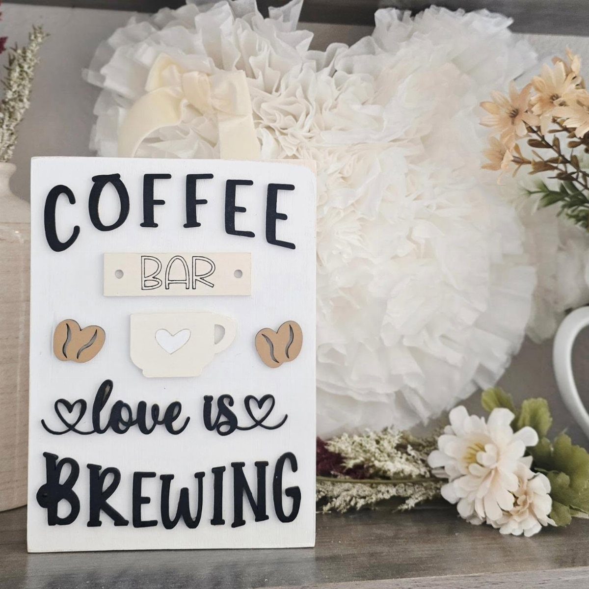 16 Farmhouse Coffee Bar Ideas for Pantry Nooks to Pallet Walls 5 A white decorative coffee bar sign with black text and wooden heart accents.