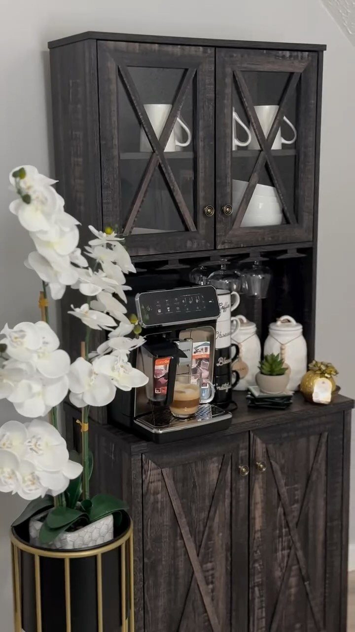 16 Farmhouse Coffee Bar Ideas for Pantry Nooks to Pallet Walls 14 Dark wood farmhouse hutch containing a coffee maker, white mugs, and decorative canisters on a counter.