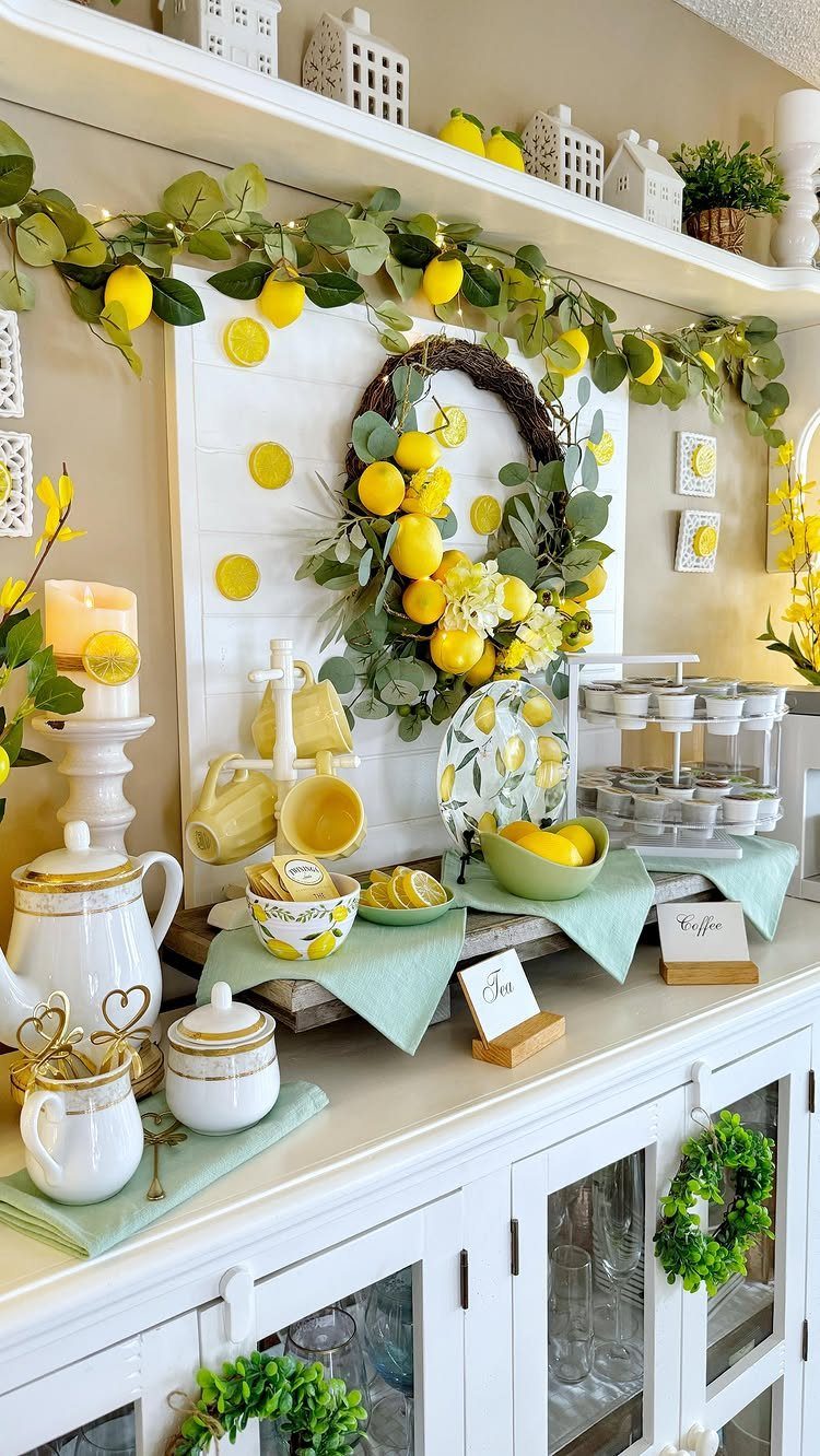 16 Farmhouse Coffee Bar Ideas for Pantry Nooks to Pallet Walls 9 Lemon themed coffee bar setup on a white sideboard with yellow mugs and greenery.