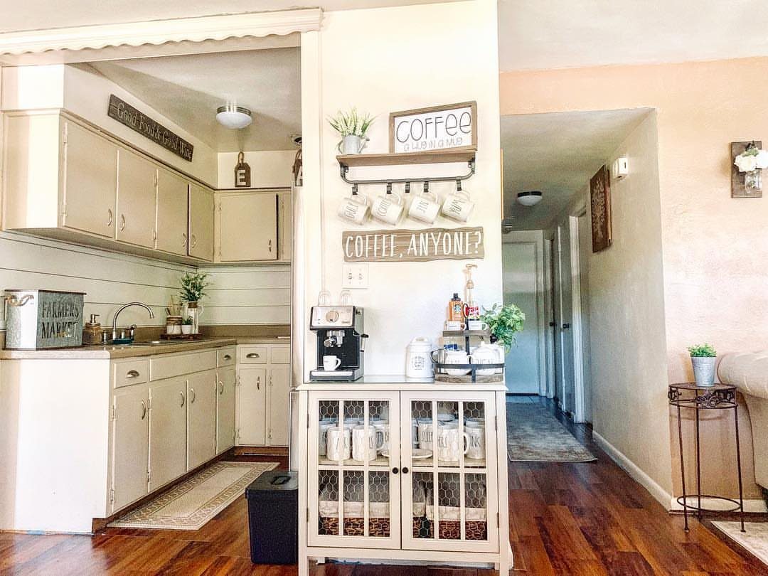 16 Farmhouse Coffee Bar Ideas for Pantry Nooks to Pallet Walls 4 A white sideboard coffee station with an espresso machine and mugs on a wall rack.