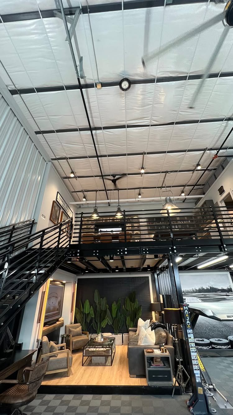 Modern garage interior with a living room setup and a mezzanine loft level.