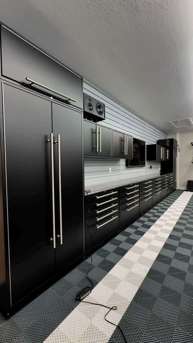 Garage Storage and Workshop: 8 Ideas That Actually Fit 6 Black garage cabinets with silver handles and a white countertop in a modern workshop.