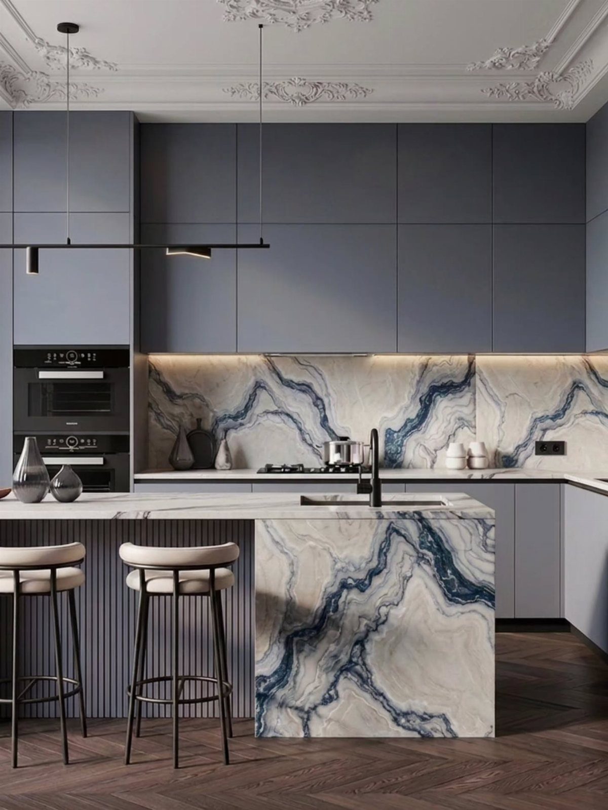 Modern kitchen with blue cabinets and a large marble island featuring blue and grey veining.