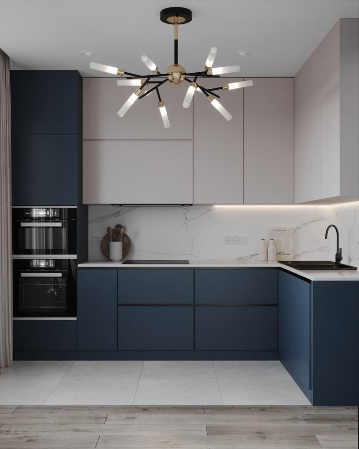 Modern kitchen with light grey upper cabinets and navy blue lower cabinets with marble backsplash.