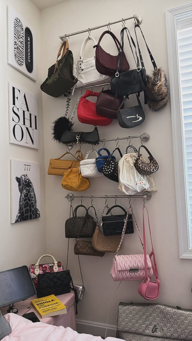Various colorful handbags hanging from metal wall-mounted racks in a room.