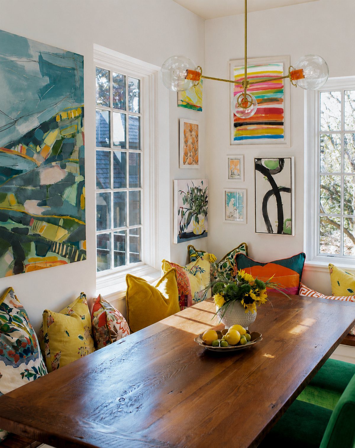 Colorful patterned and yellow throw pillows on a built-in dining room banquette.