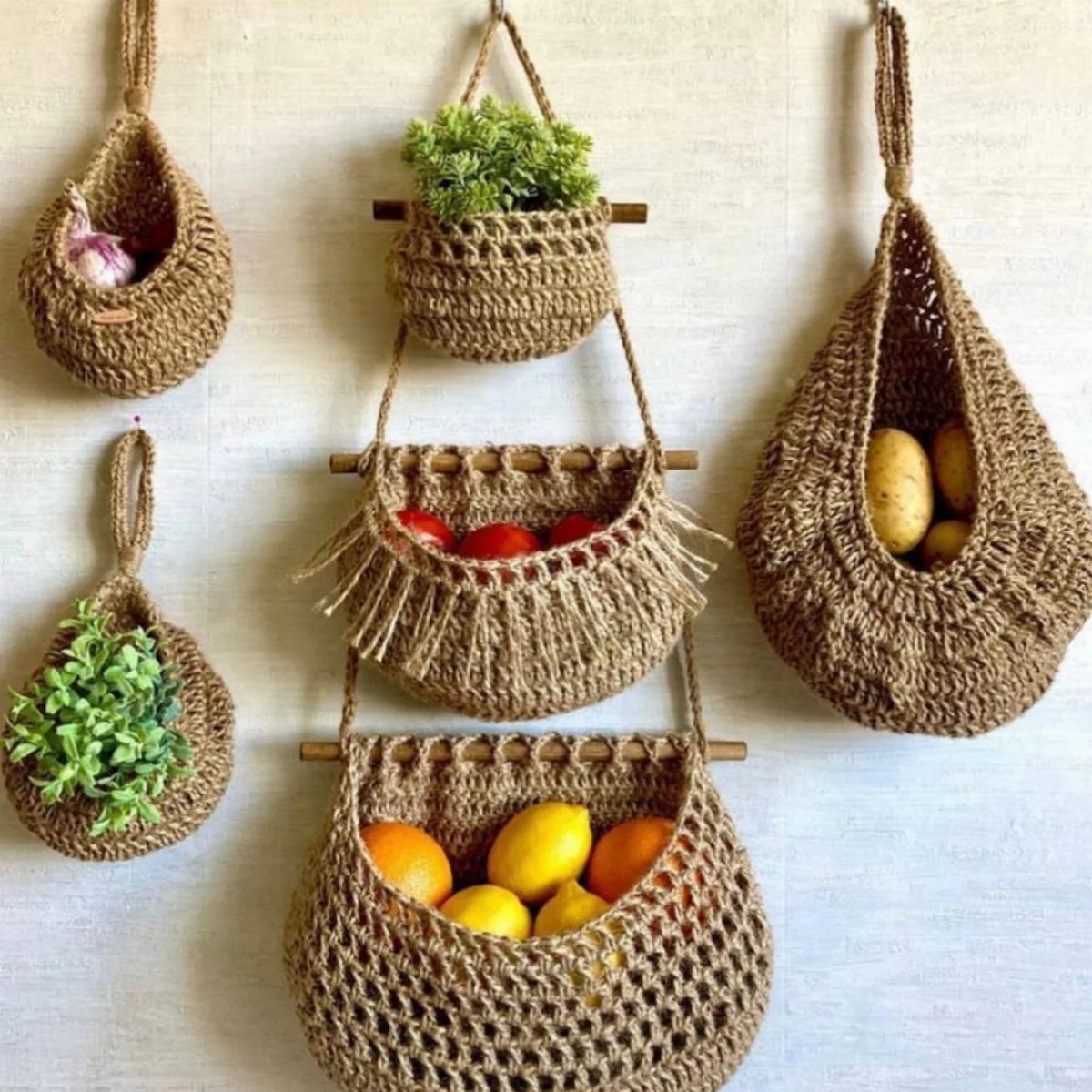 13 Kitchen Organization Ideas for Small Spaces That Free Up Real Room 2 Woven jute hanging baskets containing garlic, plants, tomatoes, and citrus fruits mounted on a wall.