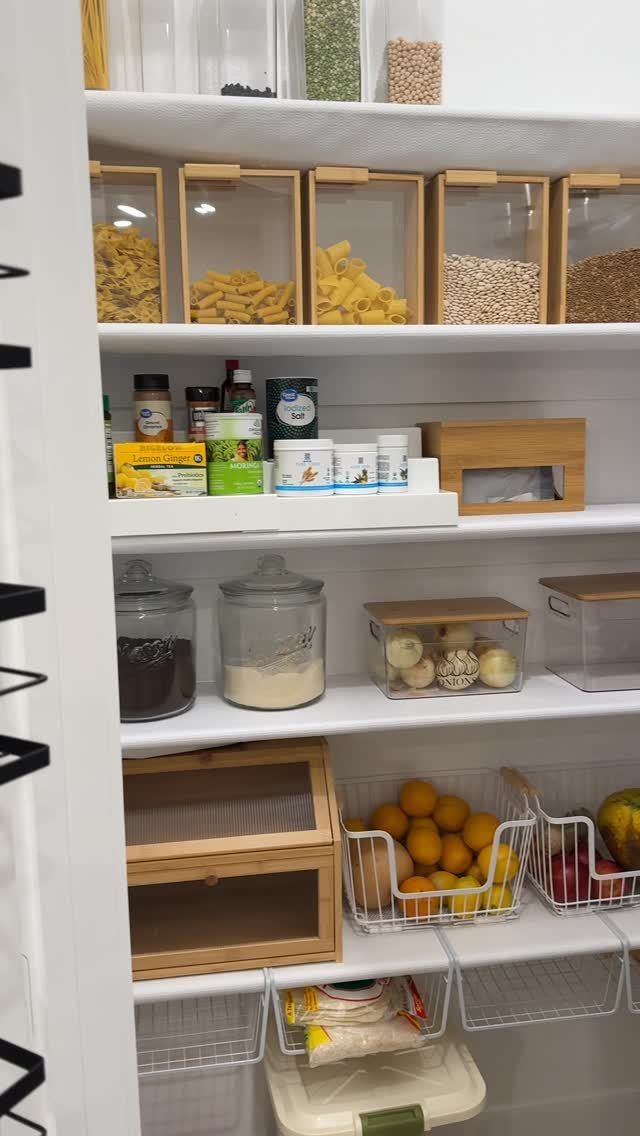 13 Kitchen Organization Ideas for Small Spaces That Free Up Real Room 10 Organized pantry shelves featuring wooden containers of pasta, glass jars, and wire baskets of fruit.