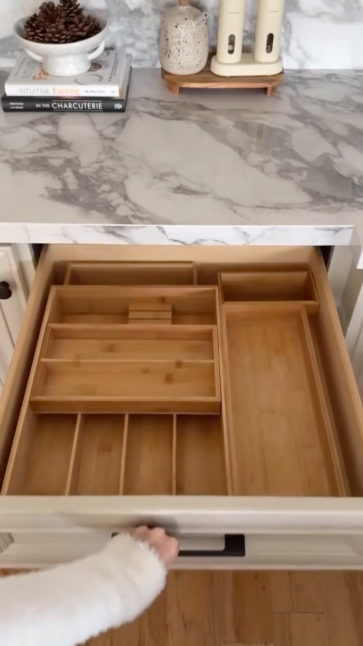 7 Kitchen Storage Tray Ideas for Cabinets and Drawers 6 Bamboo trays with various compartments organized inside an open kitchen drawer under a marble countertop.