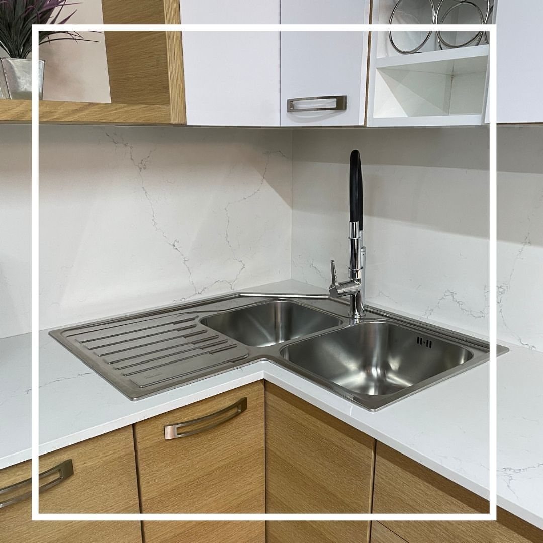 12 Latest Kitchen Sink Design Ideas for 2026 12 Stainless steel corner sink with two bowls and a draining board in a white marble countertop.