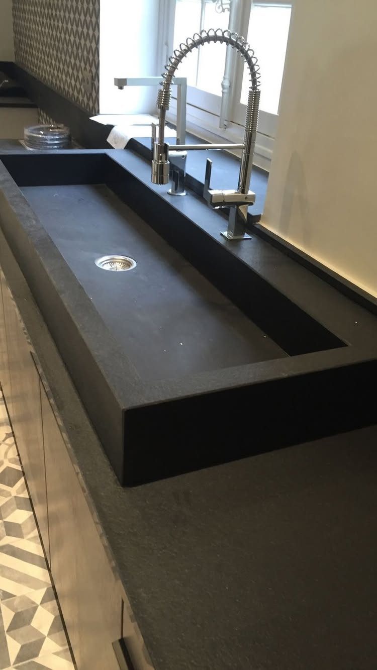 12 Latest Kitchen Sink Design Ideas for 2026 3 A matte black rectangular sink with a chrome spring-neck faucet on a dark countertop.