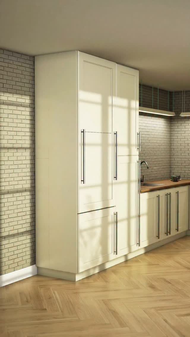 Cream kitchen cabinets with long metal handles against a white brick wall and herringbone wood floor.