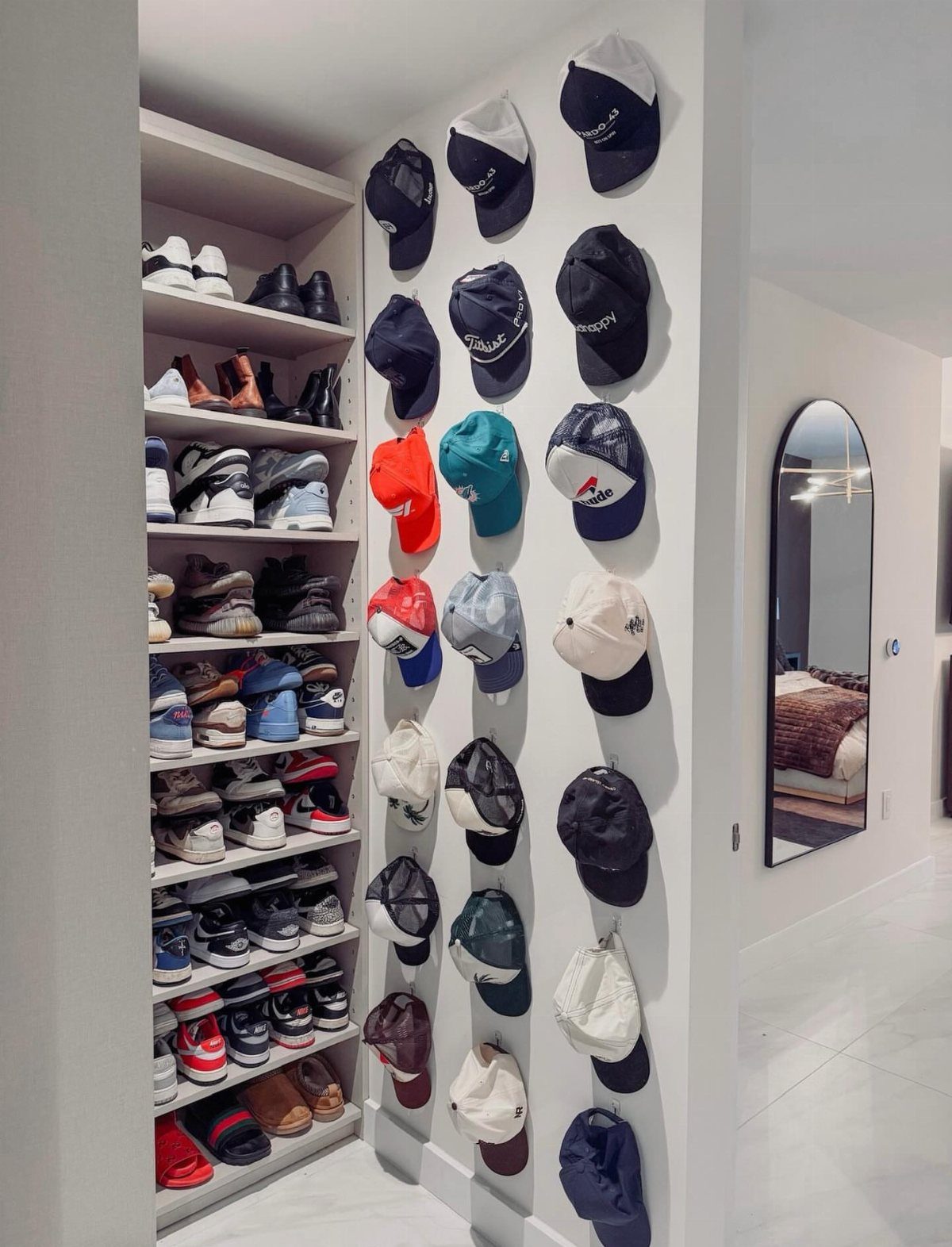 11 Ideas to Organize a Closet for Maximum Storage 7 Baseball caps mounted on a white wall next to shelves filled with organized shoes.