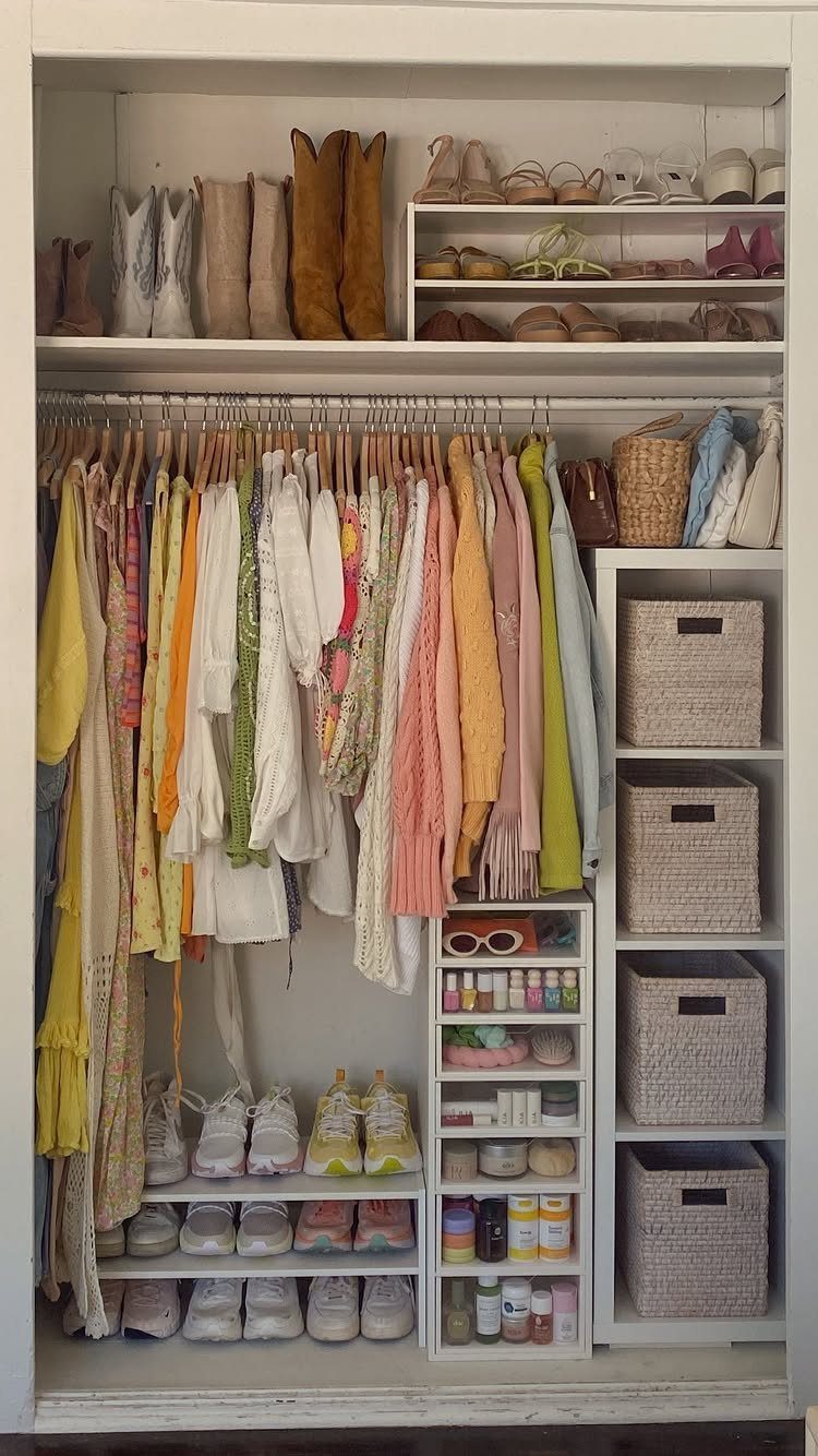 11 Ideas to Organize a Closet for Maximum Storage 8 A white closet filled with hanging colorful clothes, various shoes, and woven storage baskets.