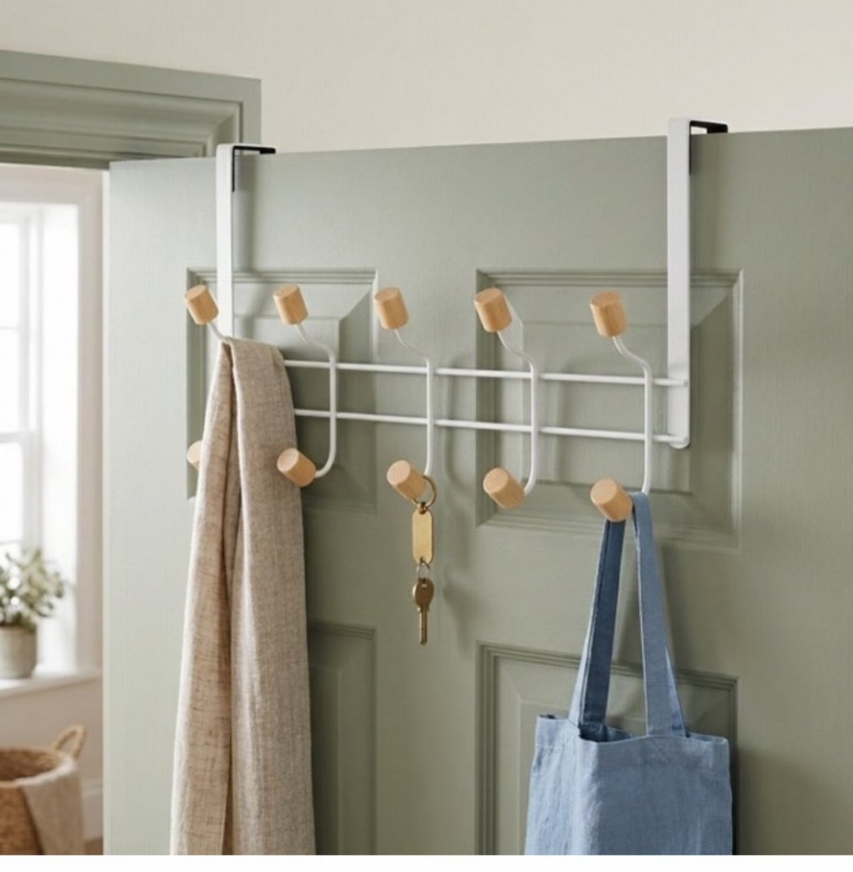 11 Ideas to Organize a Closet for Maximum Storage 4 White over-the-door hook rack with wooden knobs holding a scarf, keys, and a blue tote bag.