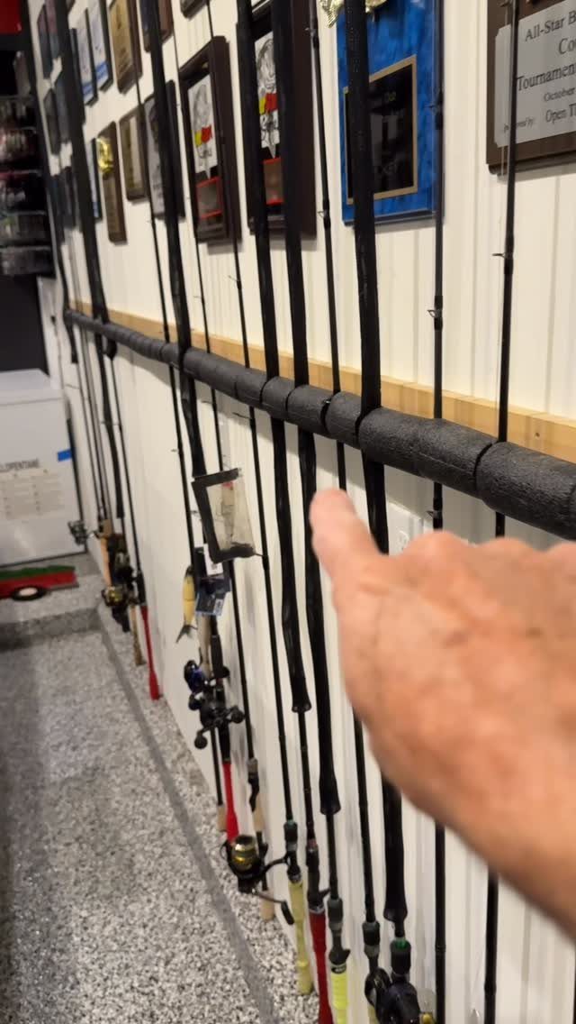 22 Organize a Garage Ideas for Workbenches, Zones & Wall Systems 22 A hand points to fishing rods organized in a DIY foam pipe holder on a wall.