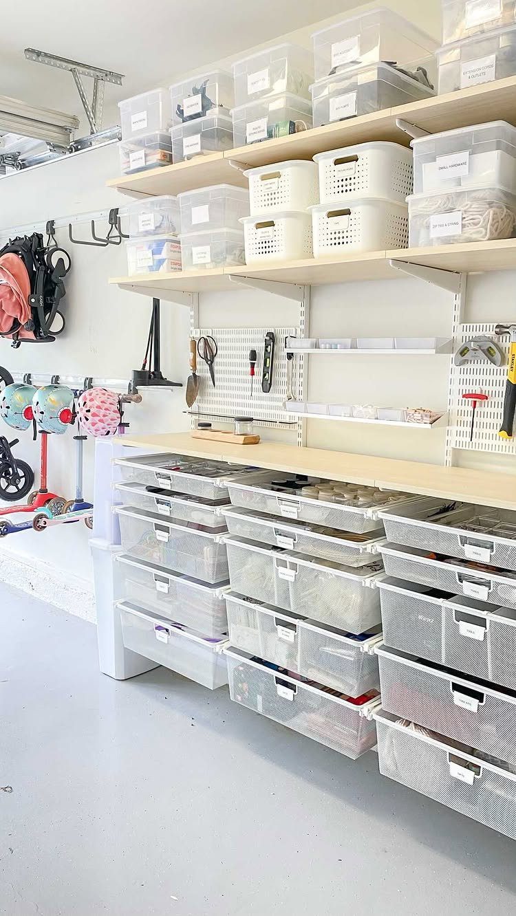 22 Organize a Garage Ideas for Workbenches, Zones & Wall Systems 2 Organized garage storage with clear bins on shelves, a workbench, and many drawers below.