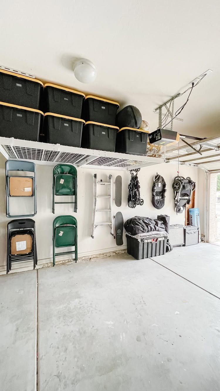 22 Organize a Garage Ideas for Workbenches, Zones & Wall Systems 14 Garage storage with overhead bins, folded chairs, a ladder, and items hanging on wall hooks.