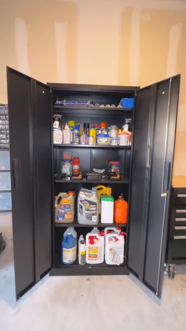 22 Organize a Garage Ideas for Workbenches, Zones & Wall Systems 20 Black metal storage cabinet with open doors revealing shelves filled with various chemical jugs and bottles.