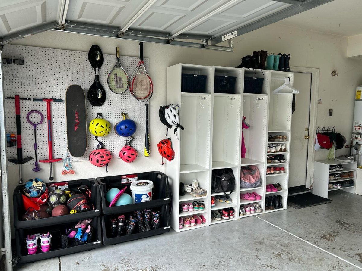 22 Organize a Garage Ideas for Workbenches, Zones & Wall Systems 12 Sports equipment including rackets, helmets, and balls organized on pegboards and white shelving units.