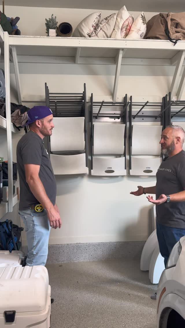 22 Organize a Garage Ideas for Workbenches, Zones & Wall Systems 17 Two men standing in a garage with white wall-mounted storage units installed on shelves.
