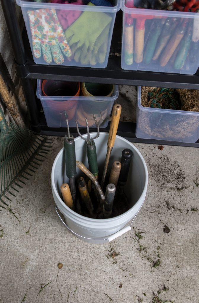 Two 5-gallon buckets filled with gardening tools.