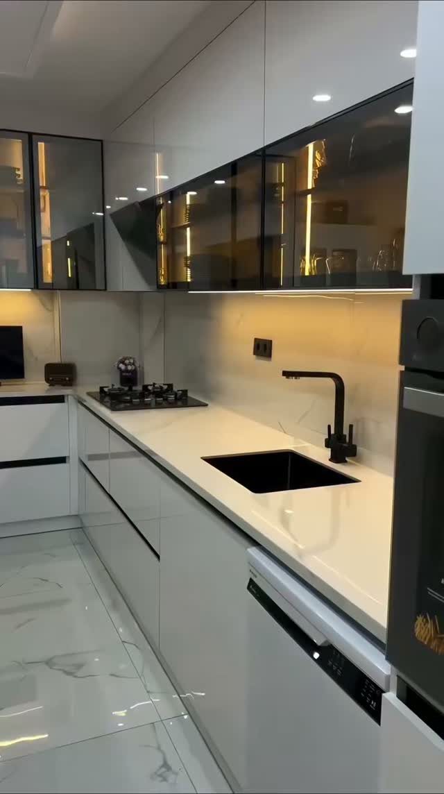 20 Simple and Small Kitchen Design Ideas 6 Modern white kitchen with glossy cabinets, black sink, and warm under-cabinet lighting.