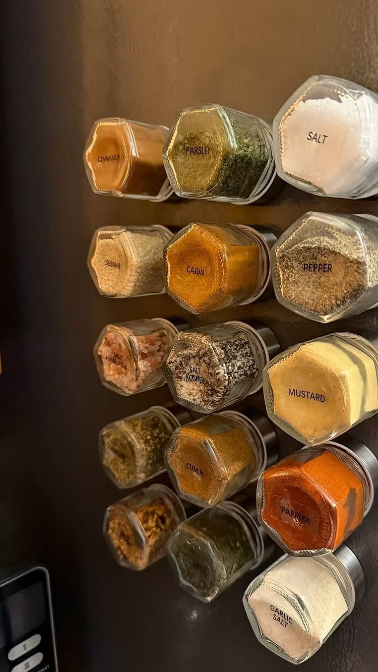 20 Simple and Small Kitchen Design Ideas 14 Hexagonal glass spice jars filled with colorful seasonings attached to a dark brown surface.