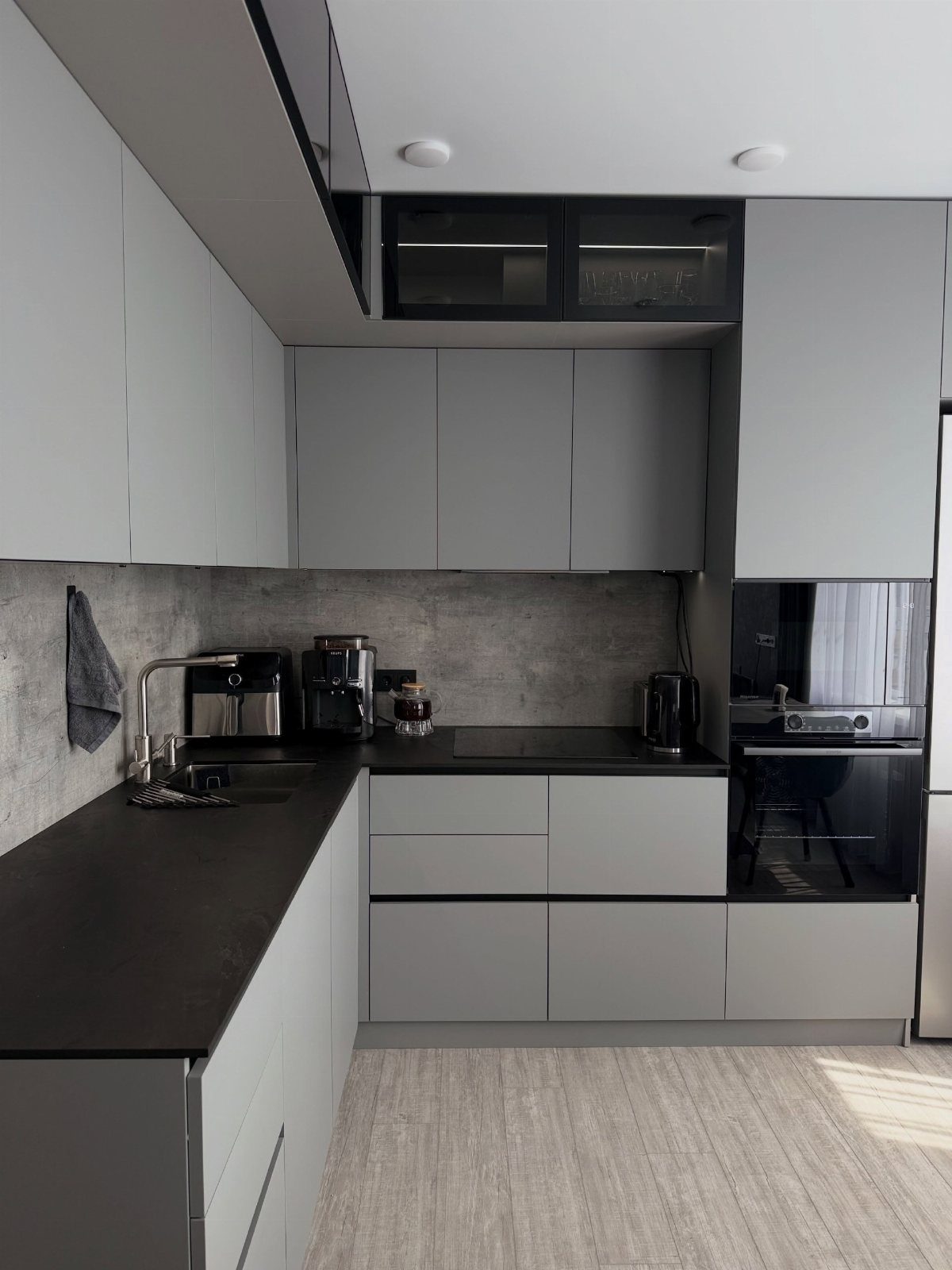 20 Simple and Small Kitchen Design Ideas 11 Modern minimalist kitchen with gray cabinets, black countertops, and a textured gray backsplash.