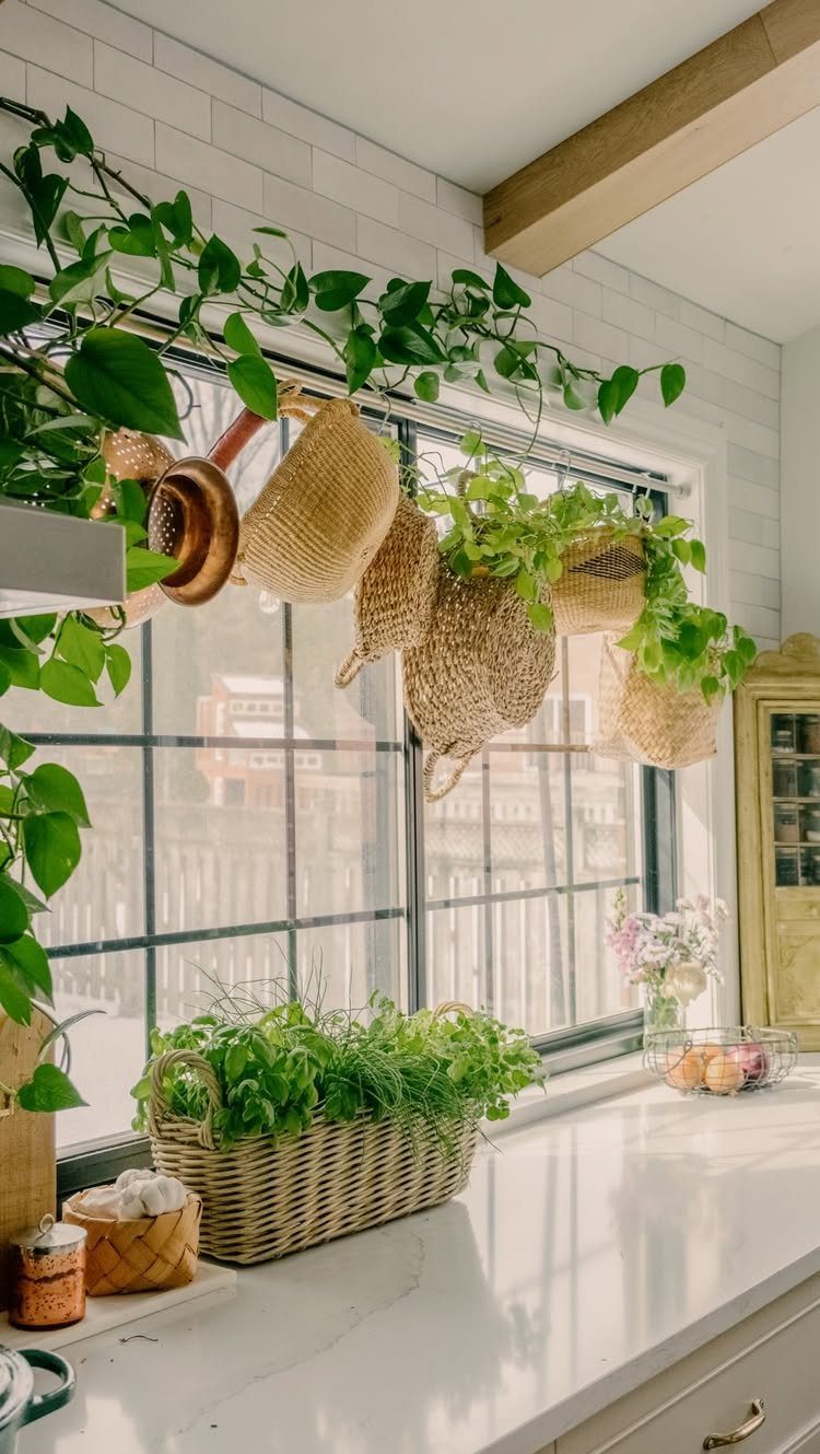 20 Simple and Small Kitchen Design Ideas 10 Woven baskets and a copper pot hanging from a rod in front of a window.