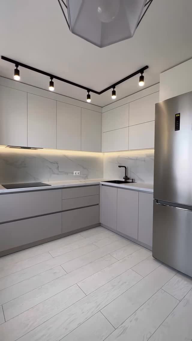 20 Sleek Kitchen Cabinet Design Ideas for 2026 17 Modern kitchen with light grey handleless cabinets, marble backsplash, and a stainless steel refrigerator.