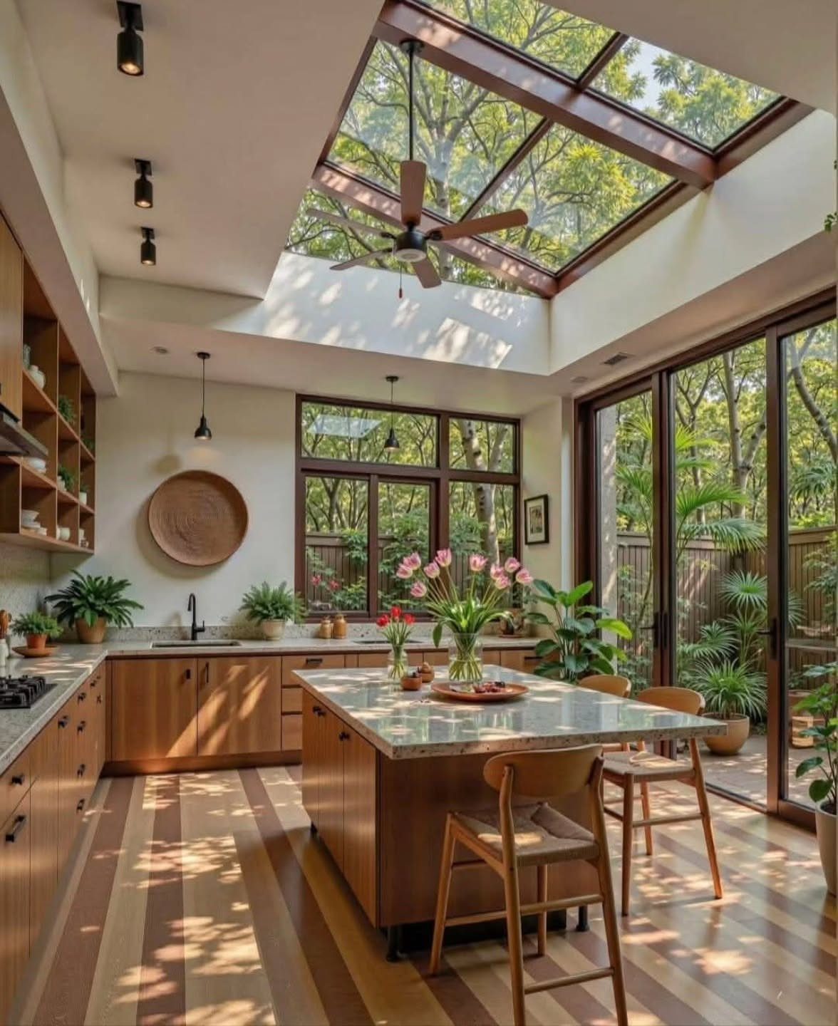 20 Sleek Kitchen Cabinet Design Ideas for 2026 2 A bright kitchen with wooden cabinetry and a large glass skylight overlooking green trees.