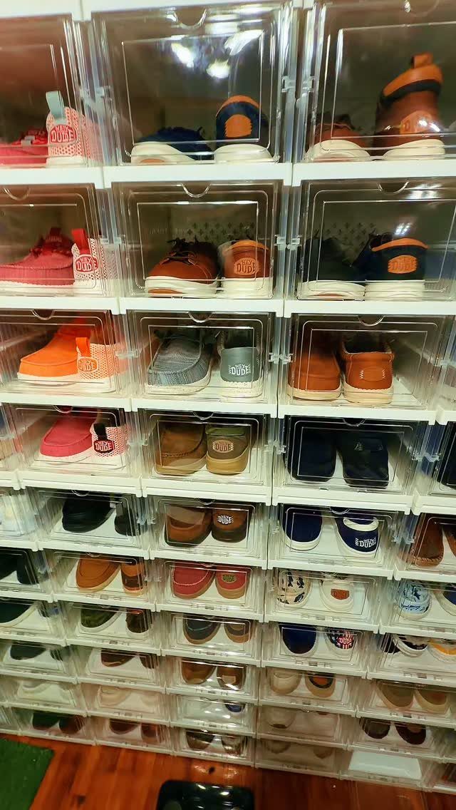 Clear plastic stackable containers filled with various colorful sneakers arranged in a vertical grid.
