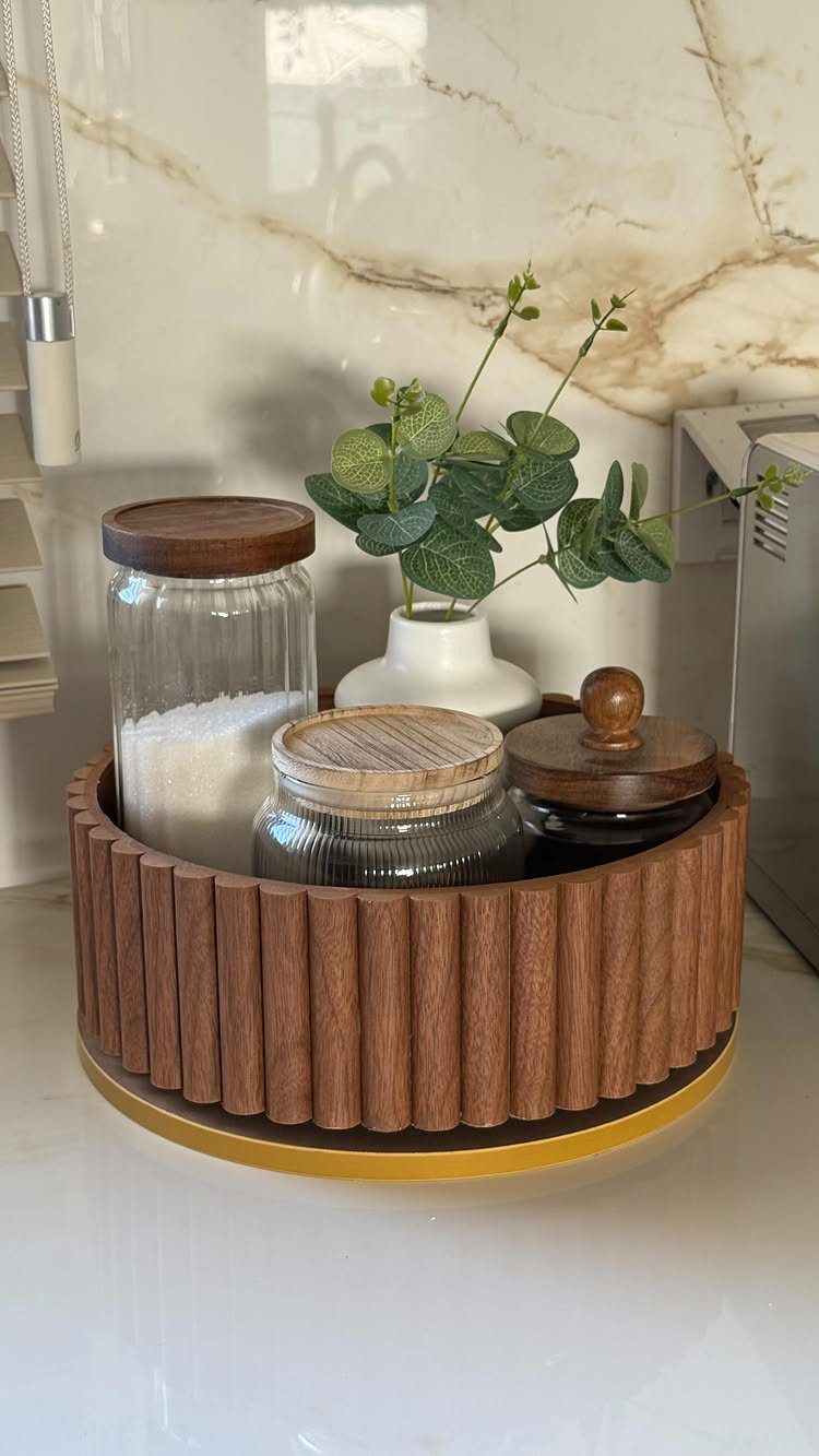 14 Small Apartment Storage Hacks and Genius Finds for 2026 10 Wooden fluted lazy susan holding glass jars and a small vase of eucalyptus leaves.