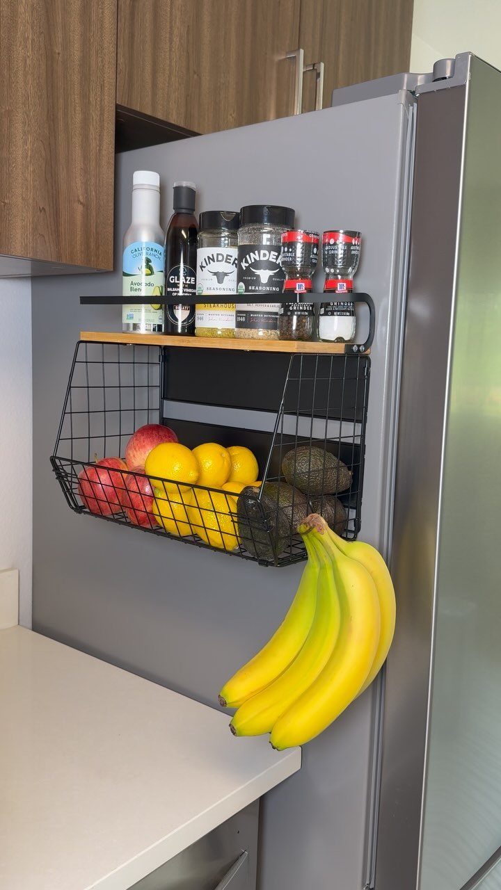14 Small Apartment Storage Hacks and Genius Finds for 2026 8 Magnetic spice rack and wire fruit basket attached to a silver refrigerator side.