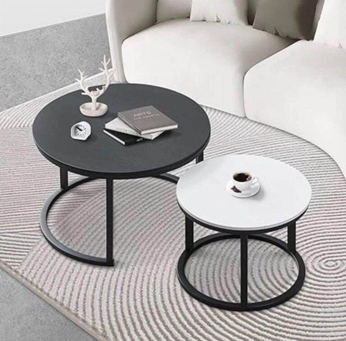 14 Small Apartment Storage Hacks and Genius Finds for 2026 6 Two circular nesting coffee tables with black and white tops on a textured rug.