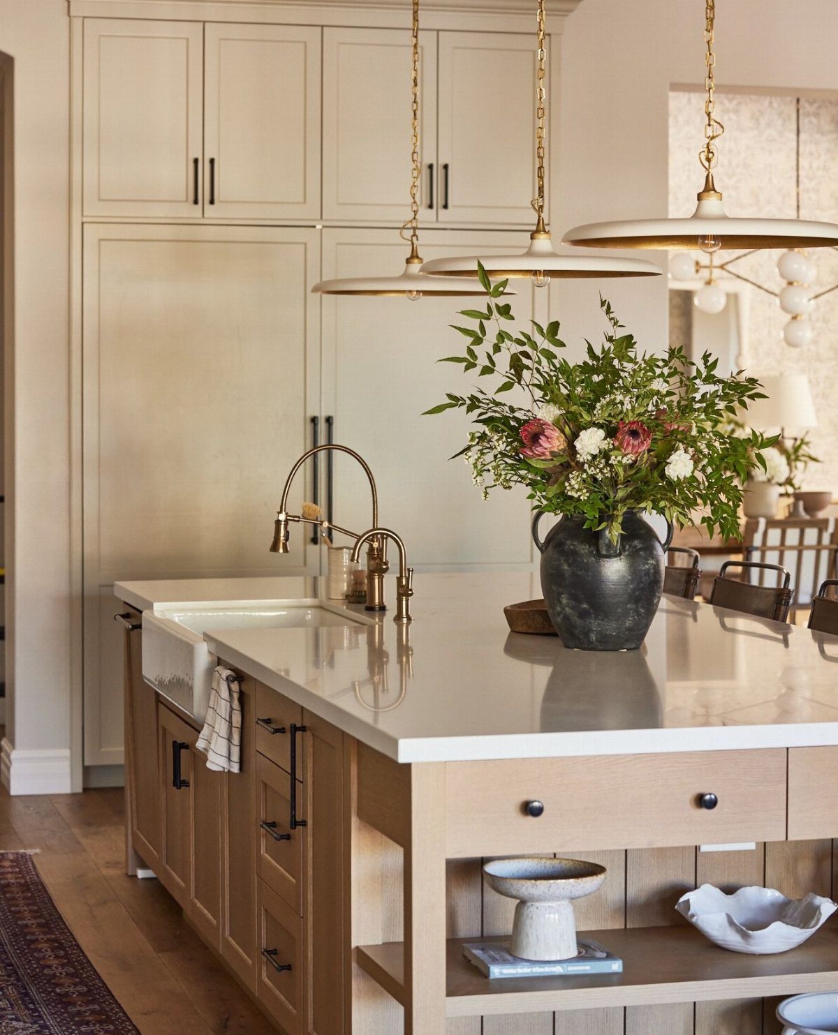 A wooden kitchen island with a white marble top and open shelving on the side.