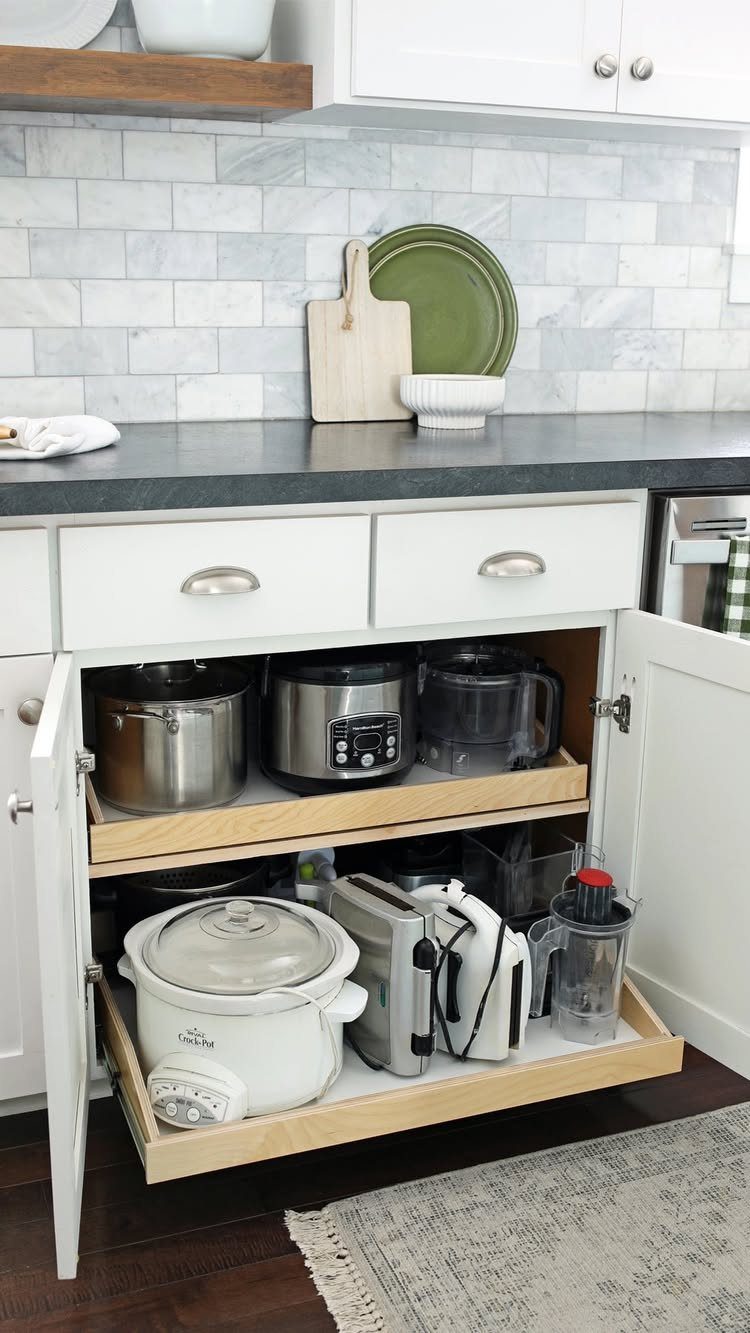 Vertical Pull Out Cabinet Kitchen: 7 Ideas That Fix Stiff Necks 1 Wooden pull-out shelves inside an open white kitchen cabinet holding various small kitchen appliances.