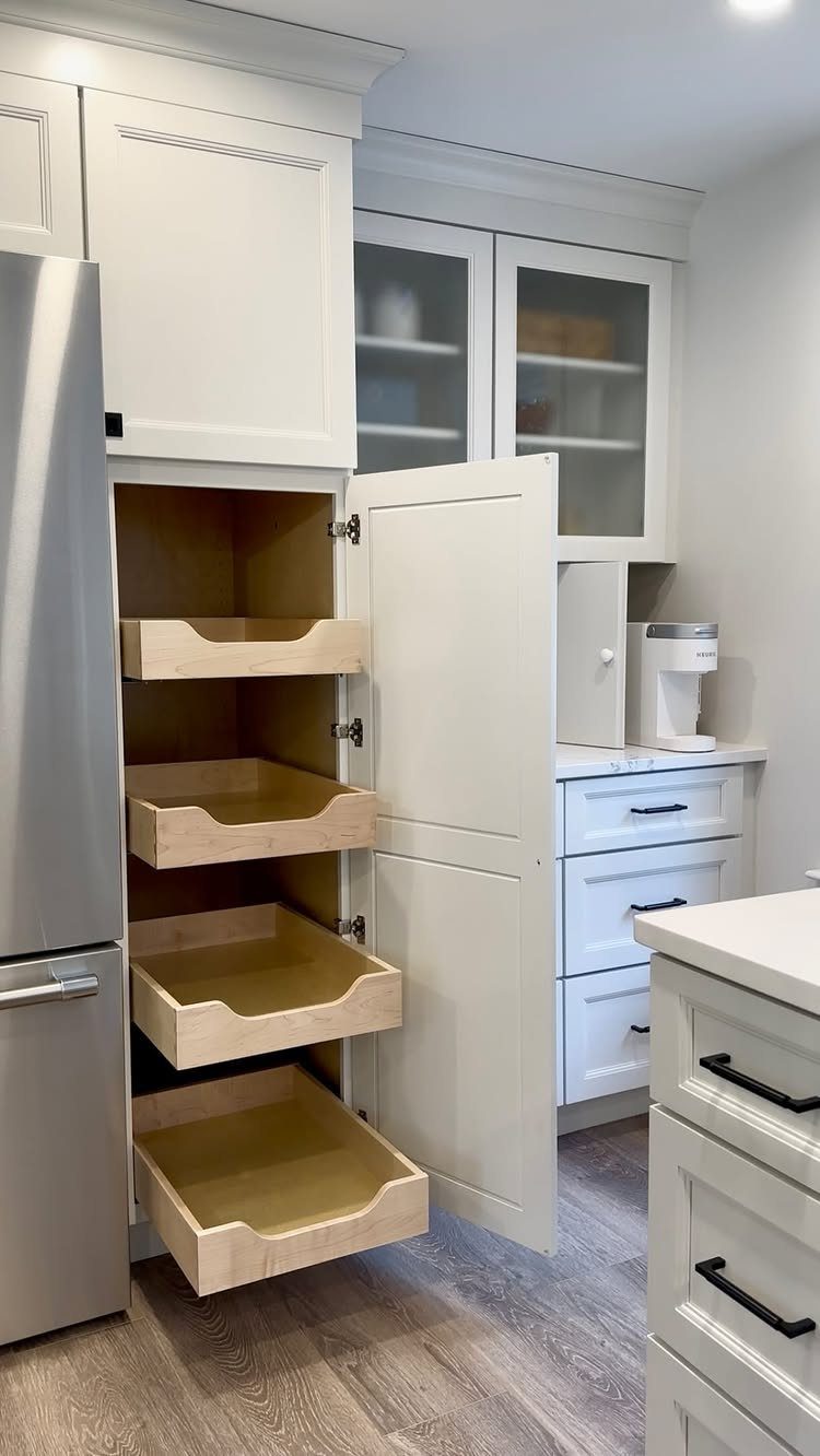 Vertical Pull Out Cabinet Kitchen: 7 Ideas That Fix Stiff Necks 2 Open white kitchen pantry cabinet showing four light wood single-height pull-out shelves next to a refrigerator.
